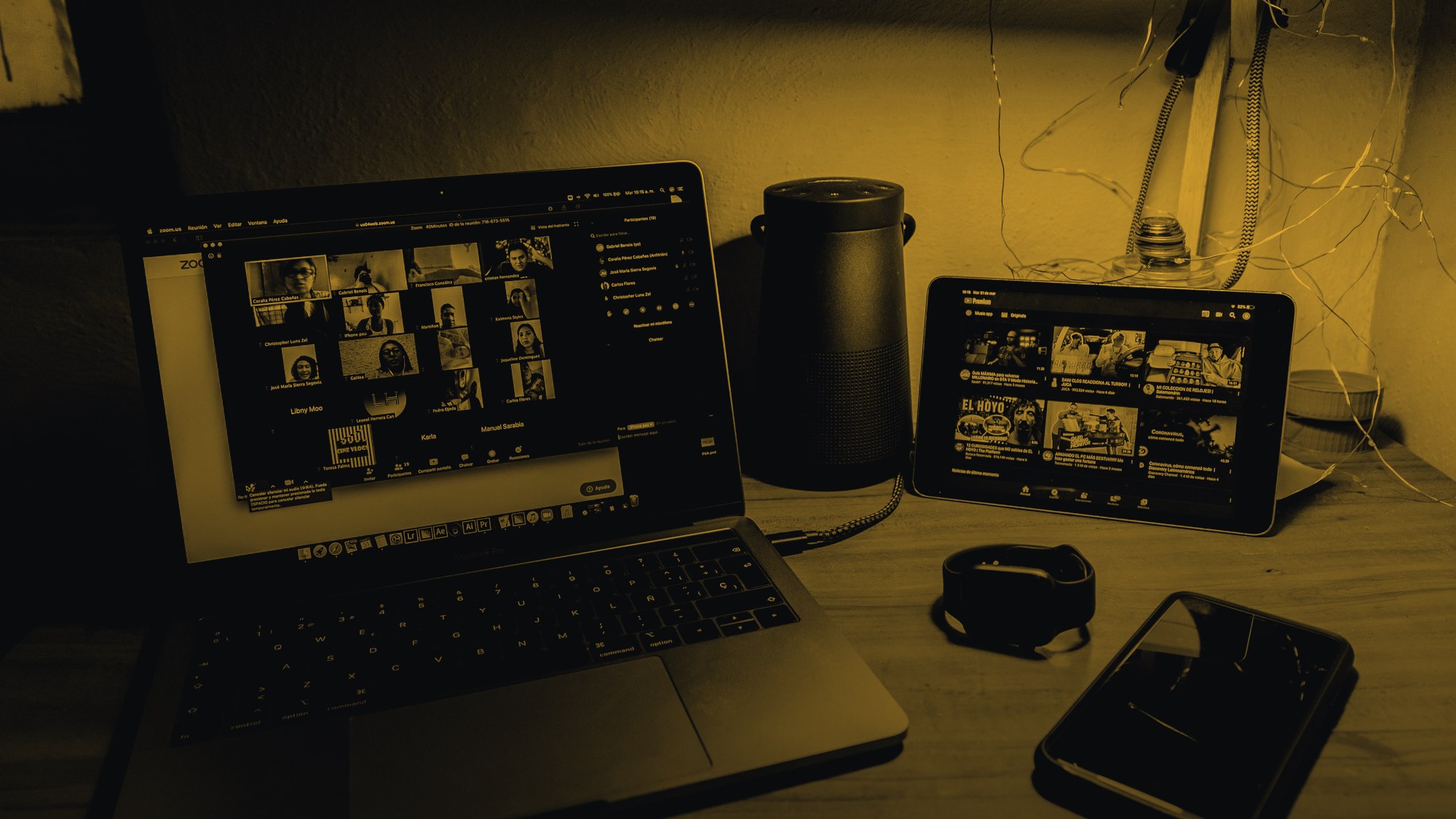 Una videochiamata di gruppo aperta su un portatile, di sera, con il telefono accanto