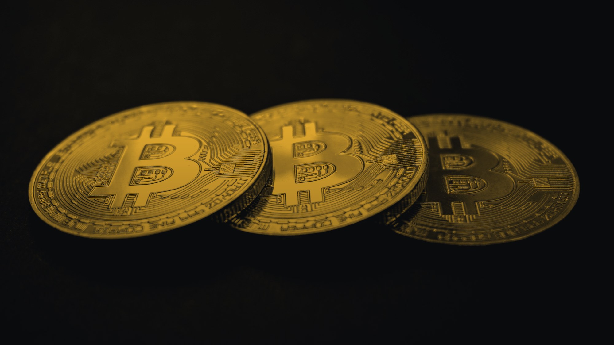 Tre monete di Bitcoin su fondo nero
