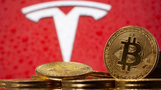 FILE PHOTO: Representations of virtual currency bitcoin are seen in front of Tesla logo in this illustration taken, February 9, 2021. REUTERS/Dado Ruvic